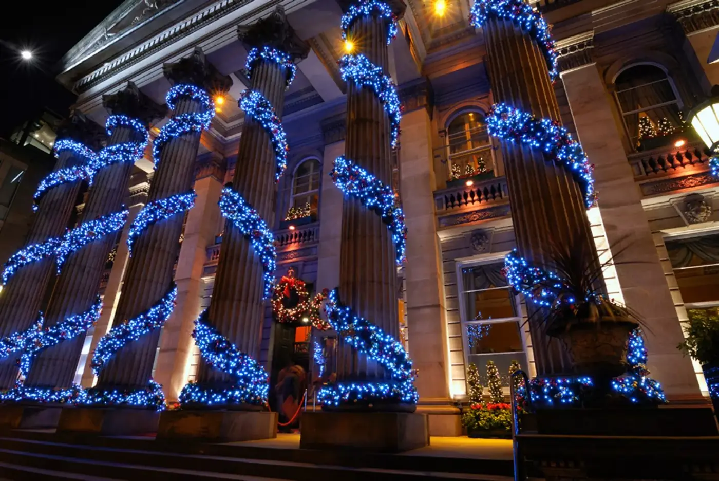 Stone columns wrapped in blue LED lights at a building entrance near Bellevue, WA