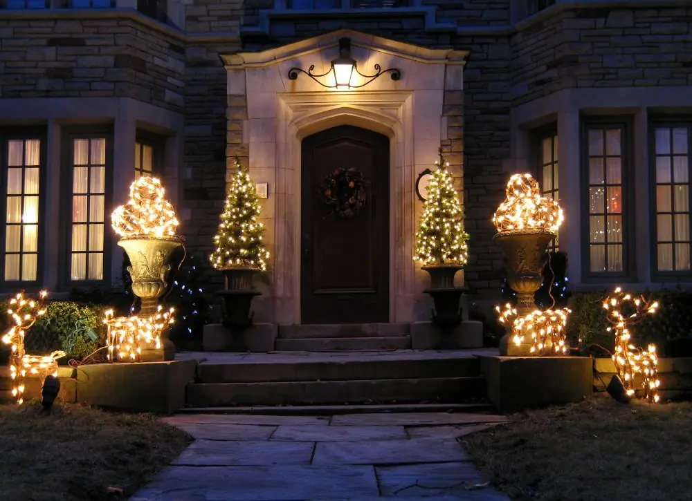 Front entry with lit topiaries and shrubs flanking the door near Bellevue, WA