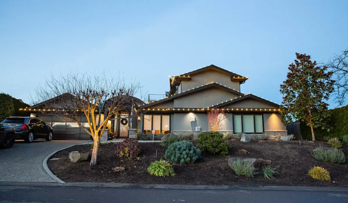Two-story home outlined in warm white C9 lights at dusk in Hunts Point, WA