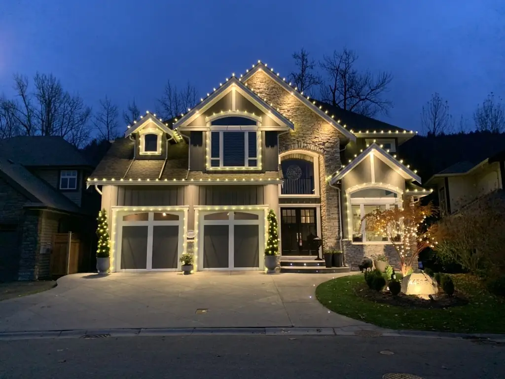 Custom C9 LED Christmas light installation along the roofline and gables of a two-story home