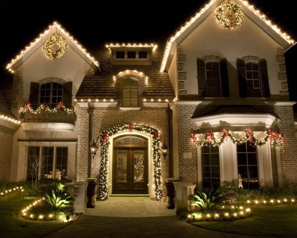 Front entry columns and roofline wrapped in warm white lights